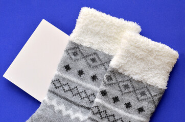 gray warm socks and card with place for text on blue background, mockup