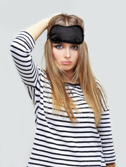 Naklejka premium Trouble Sleeping,woman trying to sleep with a mask, girl holding eye mask is the best for sleeping
