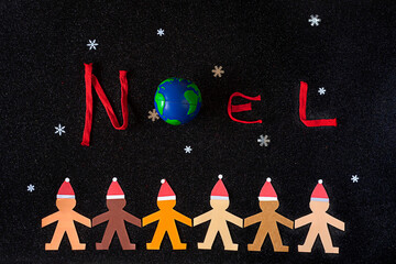 Multiracial human paper chain accompanied by the word NOEL, a little planet Earth and some...