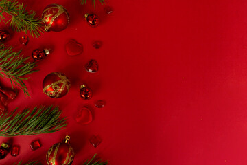 Christmas composition. Christmas red decorations, fir tree branches on red background. Flat lay, top view, copy space
