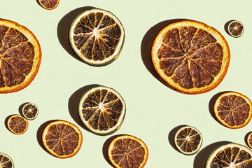 Pattern of dried citrus slices on pastel backdrop 