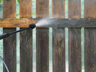 Sanitary cleaning private territory and wooden fence with equipment pressure washer, containing a...