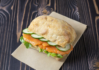 Delicious and appetizing still life with salmon sandwiches and fresh cucumber on a porcelain white plate
