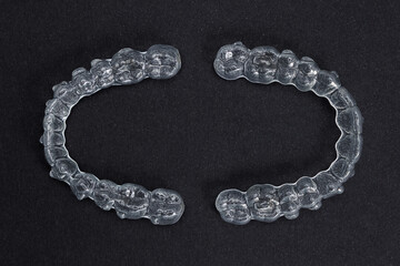 Two transparent retainers on black background. Invisalign orthodontics concept