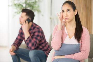 pleasant woman touching her head while judging her husband