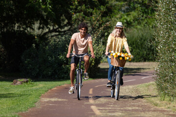 young couple is cycling in the forest