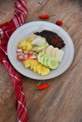 Traditional Indonesian fruits salad names "Rujak Buah", placed on the brown wooden table