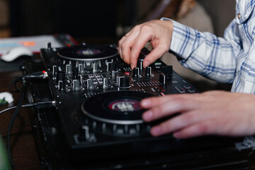 DJ's hands mix music on the mixer close-up.