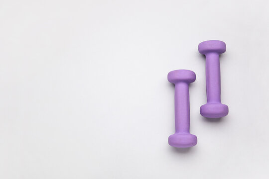 Purple dumbbells on light background