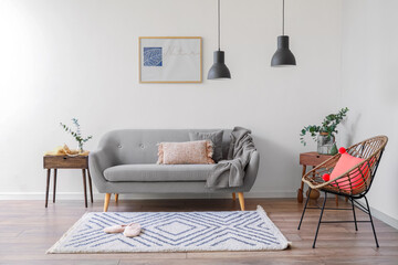 Interior of light living room with sofa and eucalyptus branches