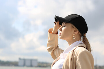 Young woman in baseball cap enjoining sunny day outdoors