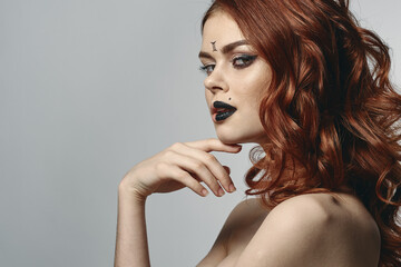 red-haired woman with bare shoulders bright makeup base zodiac sign horoscope