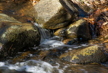 water cascading  between rocks  in a small brook in new england