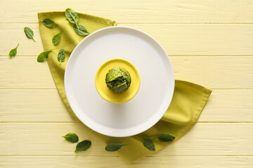 Stand with tasty spinach muffin on color wooden background
