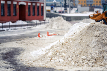 Large pile of snow at sidewalk. Snow and ice removal municipal service. Path cleared of snow,...