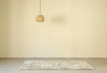 Fototapeta na wymiar Fluffy carpet and lamp hanging near light wall