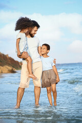 Little children with father on sea beach