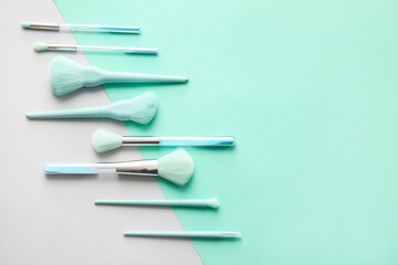 Beautiful makeup brushes on color background