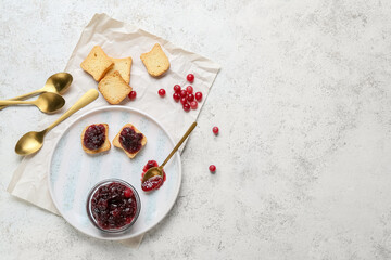 Fototapeta na wymiar Bowl of tasty cranberry jam and sandwiches on white background