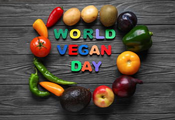 Composition with text WORLD VEGAN DAY made of colorful letters, fresh vegetables and fruits on dark wooden background