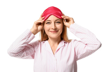 Happy mature woman in pajamas and with sleeping mask on white background