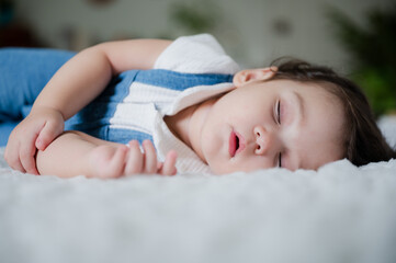 Cute little baby resting and sleeping with comfort at home on white bed