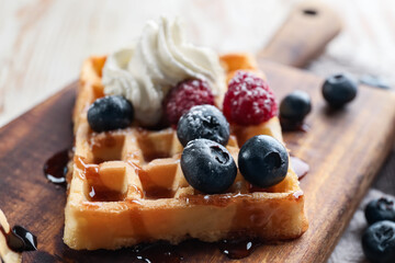 Tasty Belgian Waffle with berries on table, closeup