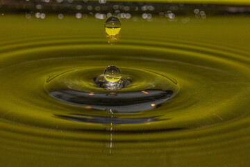 Two water orbs frozen in time dropping down that will make a big splash - stock photo