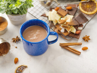 Cozy composition - on a white background, a blue cup of coffee, sweets, chocolate, decor. Delicious breakfast for one person, sweet food, hormones of happiness, festive atmosphere.