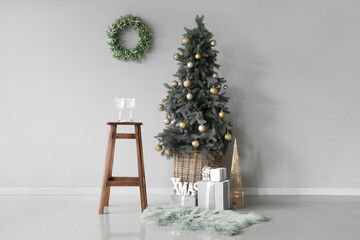 Beautiful Christmas tree with gifts and decor in interior of room