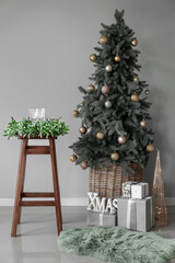 Beautiful Christmas tree with gifts and decor in interior of room