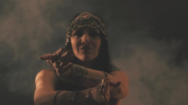 Sensual woman dancing in light and shadow. Focus on hands