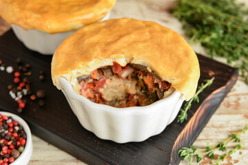 Tasty vegetable pot pies on wooden background