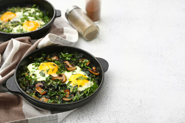 Frying pans with tasty Shakshouka on white background