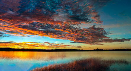 Fototapeta na wymiar Colorful sunrise/sunset behind lake - panorama