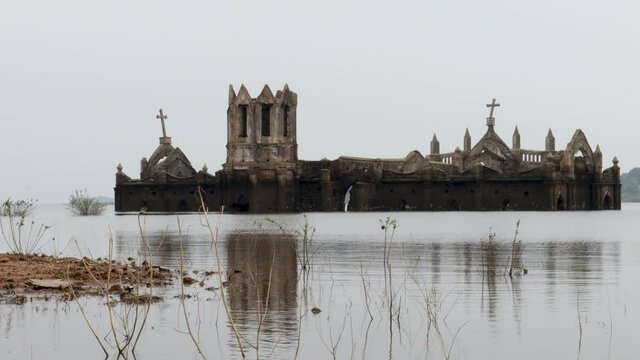 A Dramatic view of an ancient Catholic Church seen immersed in backwaters at Shetty halli village in Hassan, a famous tourist destination in Karnataka, India.