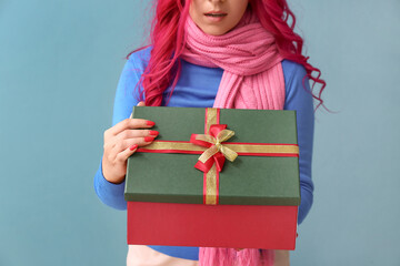 Beautiful woman opening gift box on color background