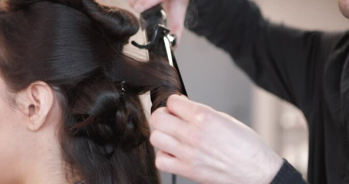 Winding curls in a beauty salon. Close-up video.
