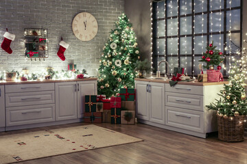 Interior of kitchen with modern furniture, stylish decor, Christmas tree and gift boxes