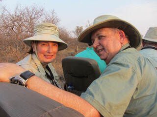 Couple in an open vehicle on safari in Kruger area of South Africa on and adventure of a lifetime