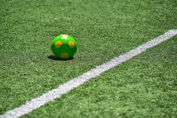 Obraz premium bright yellow-green soccer ball on the grass