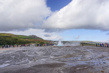 Haukadalur, Iceland: Visitors watch as the active Strokkur geyser erupts, sending jets of water and steam into the air every few minutes.