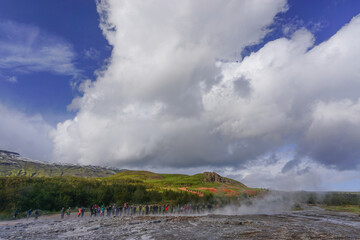 Haukadalur, Iceland: Visitors wait for the active Strokkur geyser to erupt. It sends jets of water and steam into the air every few minutes.