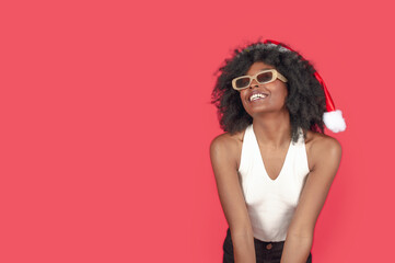 young brunette afro girl, wearing christmas hat happy for the beginning of christmas with copy space left wing