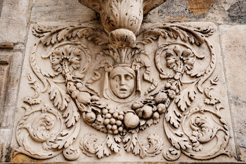 Woman face with floral patterns on the stone slab of the Duomo facade. Milan, Italy
