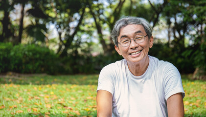 Naklejka na ściany i meble Portrait of healthy happy senior asian old man in the park outdoors exercise stretching his arms. Spring healthcare lifestyle grandfather retirement wellness healthy, Chinese old men concept