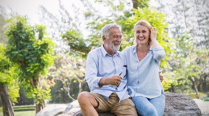 Happy old elderly caucasian couple smiling in park on sunny day, hoot senior couple relax in spring summer time. Healthcare lifestyle elderly retirement love couple together valentines day concept