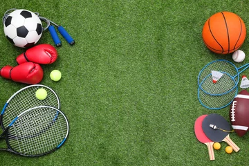 Gordijnen Different sport equipment on green grass, flat lay. Space for text © New Africa