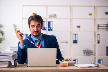 Young male employee sitting at workplace