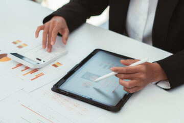 Businessman coworkers using a tablet to analysis graph company financial budget report and cost work progress and planning for future in office room.